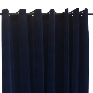 Puede incluir: Cortinas opacas de color azul marino con ojales plateados y bolsillo para barra. Las cortinas están colgadas de una barra de cortina negra.