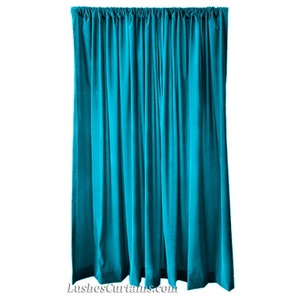 Op de afbeelding: Een turquoise fluwelen gordijnpaneel. Het gordijn is gemaakt van een zachte, luxe stof en heeft een rijke, diepe kleur.