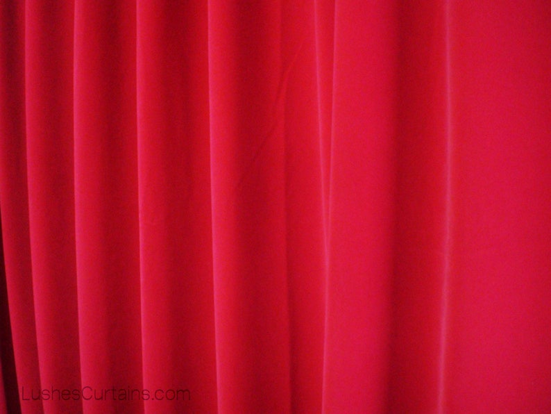 Puede incluir: Primer plano de cortinas rojas vibrantes con pliegues verticales. La tela parece ser de color liso y suave, creando un aspecto rico y texturizado. Las cortinas probablemente se utilizan para la decoraci&oacute;n del hogar.