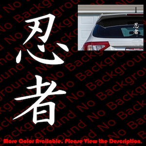 May include: White vinyl decal with the Japanese characters for "Ninja" in a bold, stylized font. The decal is shown applied to the rear window of a silver car.