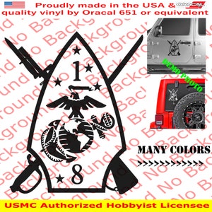 May include: Black and white decal of the 1st Marine Division emblem. The emblem features a globe, eagle, crossed rifles, and a star. The text "USMC Authorized Hobbyist Licensee" is at the bottom of the image. The decal is shown on a red Jeep.