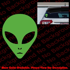 May include: Green alien head silhouette sticker. The sticker is on the back window of a white car.