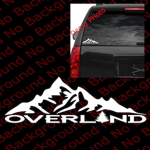 May include: White vinyl decal with a mountain range silhouette and the word "OVERLAND" in bold letters. A small pine tree is to the right of the word "OVERLAND".