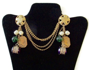 May include: A pair of gold tone chain and charm earrings with green and purple glass beads, white pearl beads, and cameo charms.