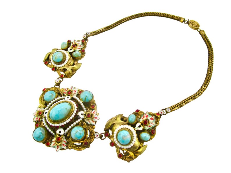 Peut inclure: Un collier en or avec une cha&icirc;ne et trois pendentifs en turquoise et en rouge. Les pendentifs sont orn&eacute;s et pr&eacute;sentent des d&eacute;tails complexes.