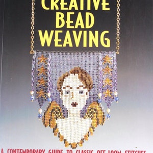 May include: A book cover with the title "CREATIVE BEAD WEAVING" in yellow letters. The cover features a beaded pendant with a woman's face and angel wings. The pendant is suspended from a gold chain. The book's subtitle is "A CONTEMPORARY GUIDE TO CLASSIC OFF-LOOM STITCHES".