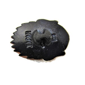 May include: Black button with a white design and the word "JAPAN" printed on the back.