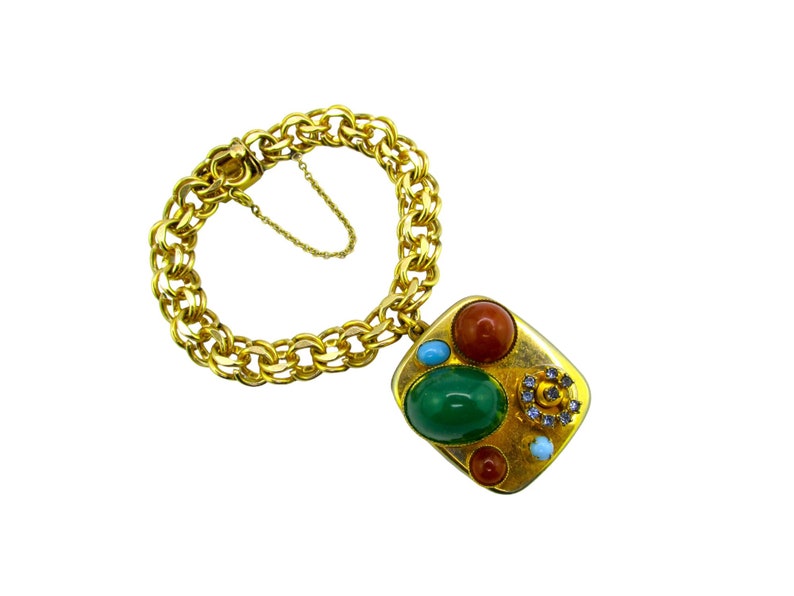 May include: A gold chain bracelet with a square charm featuring a green, red, and orange stone design.