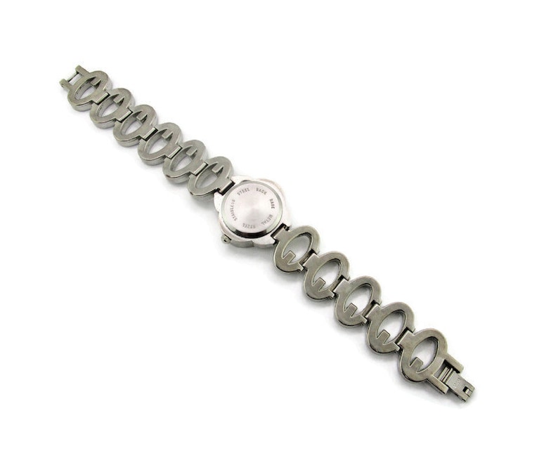 May include: A silver watch with a round face and a linked band made of interlocking ovals.