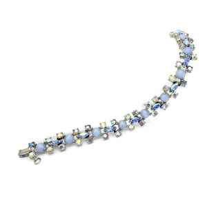 Puede incluir: Un delicado brazalete de cristal azul e iridiscente con cierre plateado. El brazalete presenta cristales redondos y en forma de marquesa alternados.