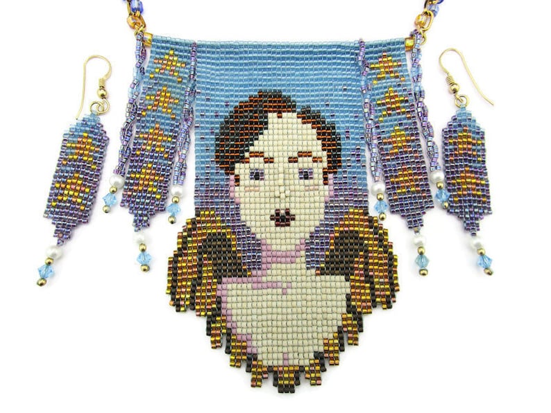 May include: A beaded necklace and earring set featuring a portrait design. The necklace has a light blue background with a portrait of a person. The earrings and necklace have gold, blue, and purple beads. The earrings have a rectangular shape with a star design.