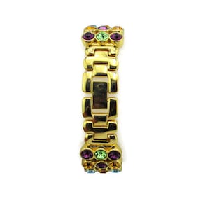 May include: A gold-tone bracelet with a chain link design and colorful crystal accents.