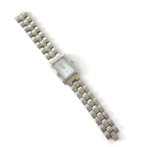 May include: A silver watch with a rectangular face and a silver metal band. The watch has a white face with black markings.