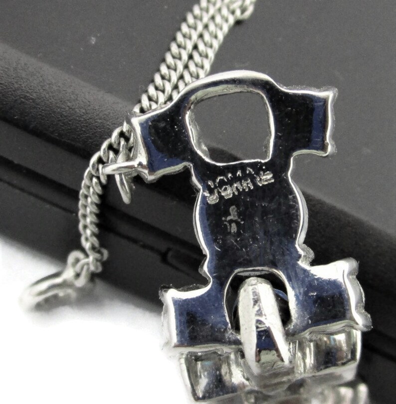 Puede incluir: Un brazalete de cadena de plata con un cierre grande, ornamentado y de plata. El cierre est&aacute; decorado con diamantes de imitaci&oacute;n y tiene la palabra "Joma" grabada en la parte posterior.