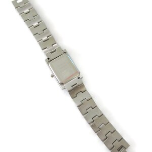 May include: A silver watch with a square face and a silver metal band.