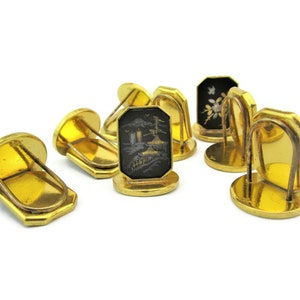 May include: Set of six gold-tone cufflinks with black enamel and intricate designs. Each cufflink features a different design, including a pagoda, a flower, and a geometric pattern.