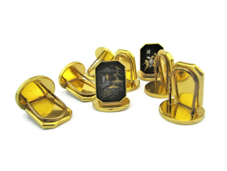 May include: Set of six gold-tone cufflinks with black enamel and intricate designs. Each cufflink features a different design, including a pagoda, a flower, and a geometric pattern.
