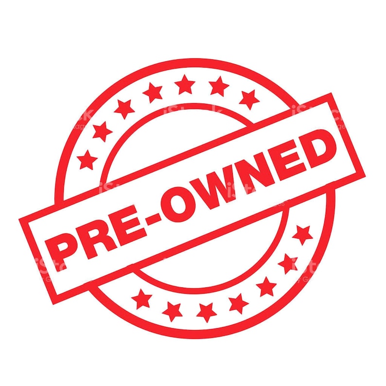 May include: Red circular stamp with the text "PRE-OWNED" in white letters. The stamp has a white background and is surrounded by a ring of red stars.