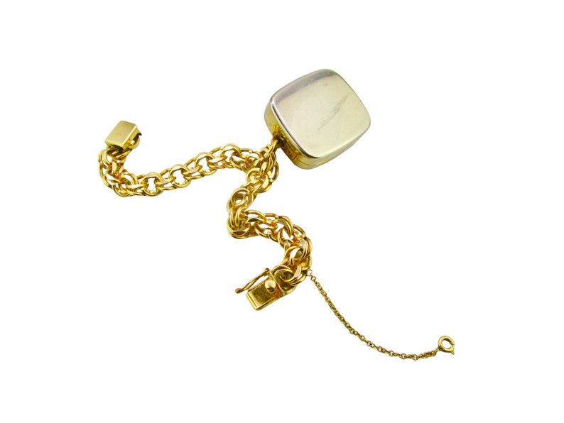 May include: A gold chain bracelet with a square-shaped pendant. The pendant is made of a silver-toned metal and has a smooth, polished finish.