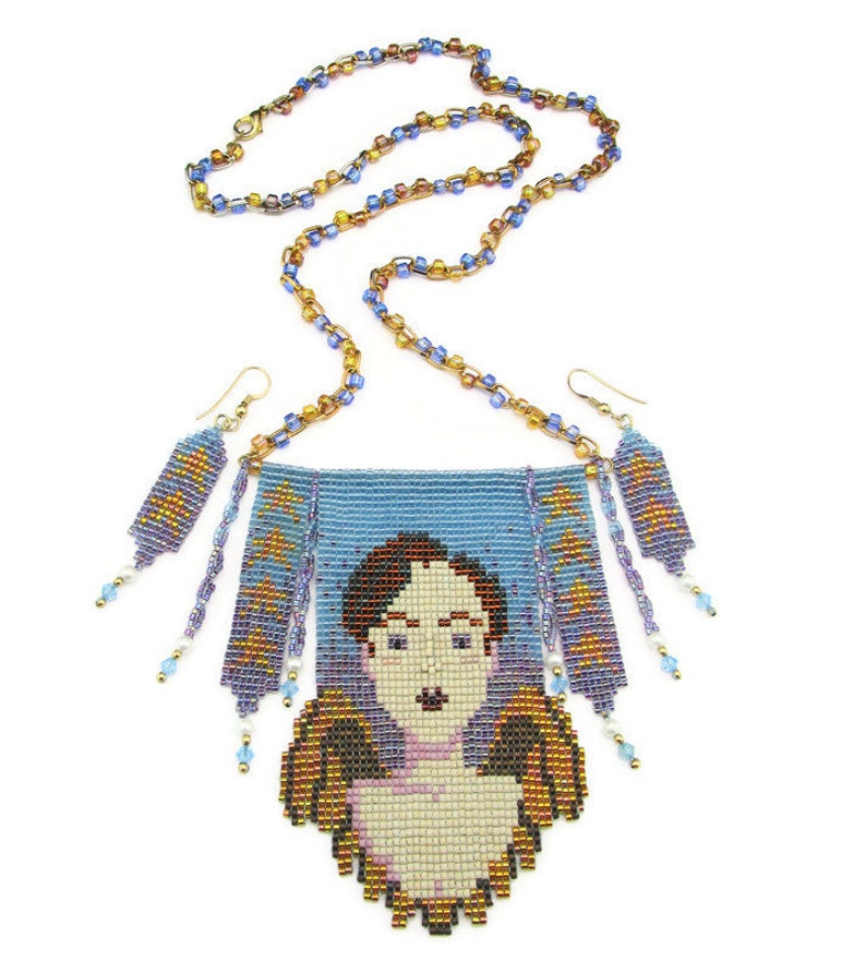 May include: A beaded necklace and earring set featuring a portrait design. The necklace has a blue background with a pixelated face and angel wings. The earrings and necklace chain are made of small, colorful beads.