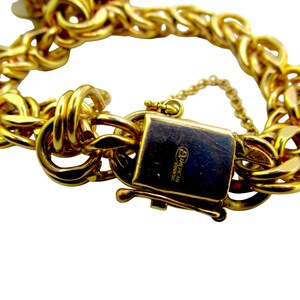 May include: Gold chain bracelet with a clasp that reads "American Jewelry".