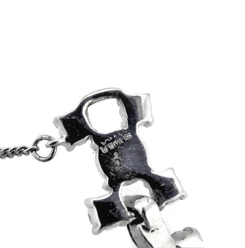 Puede incluir: Collar de cadena de plata con un dije de plata en forma de una letra estilizada 'R'. El dije tiene la palabra 'ROMA' inscrita en &eacute;l.