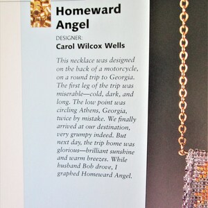 May include: A close-up of a beaded necklace with a gold chain. The necklace has a rectangular pendant with a mix of orange, purple, and gold beads. The text on the page reads "Homeward Angel" and "Carol Wilcox Wells."