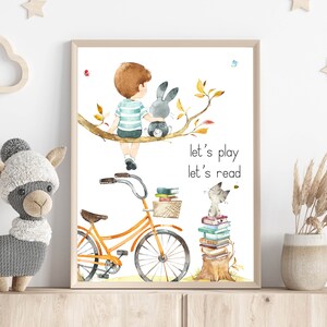 May include: A watercolor illustration of a boy sitting on a tree branch with a bunny rabbit. The boy is wearing a blue and white striped shirt. The bunny is gray. Below the boy and bunny is a bicycle with a basket full of books. A cat is sitting on top of a stack of books. The text "let's play let's read" is written below the bicycle and cat.