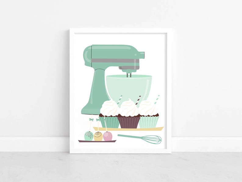 May include: A mint green stand mixer with a bowl and a whisk. Three cupcakes with white frosting and sprinkles are on a plate in front of the mixer. Three round candies are on a plate next to the whisk.
