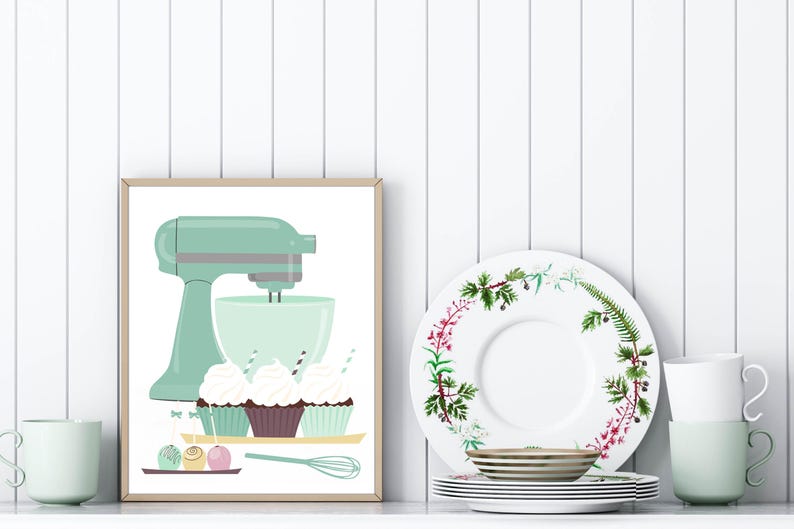 May include: A framed illustration of a green stand mixer with a bowl and three cupcakes with green, brown, and white frosting. The cupcakes are on a tray with a whisk and three round candies.