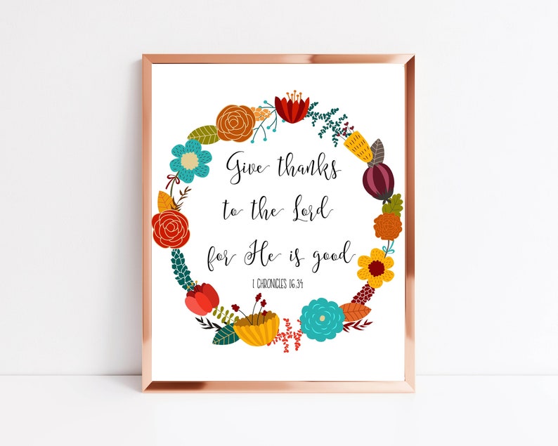 May include: A printable art print with a floral wreath design. The wreath is made up of colorful flowers and leaves. The text in the center reads "Give thanks to the Lord for He is good. 1 Chronicles 16:34".