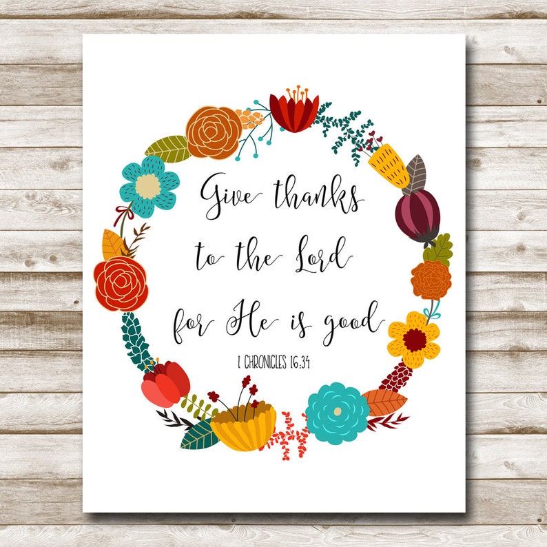 May include: A white printable art print with a floral wreath design in shades of red, orange, yellow, green, blue, and purple. The text inside the wreath reads "Give thanks to the Lord for He is good. 1 Chronicles 16:34".