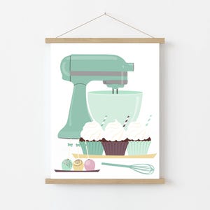 May include: A mint green stand mixer with a bowl and a whisk attachment. Three cupcakes with white frosting and sprinkles are in front of the mixer. There are also three round cake pops with colorful sprinkles.