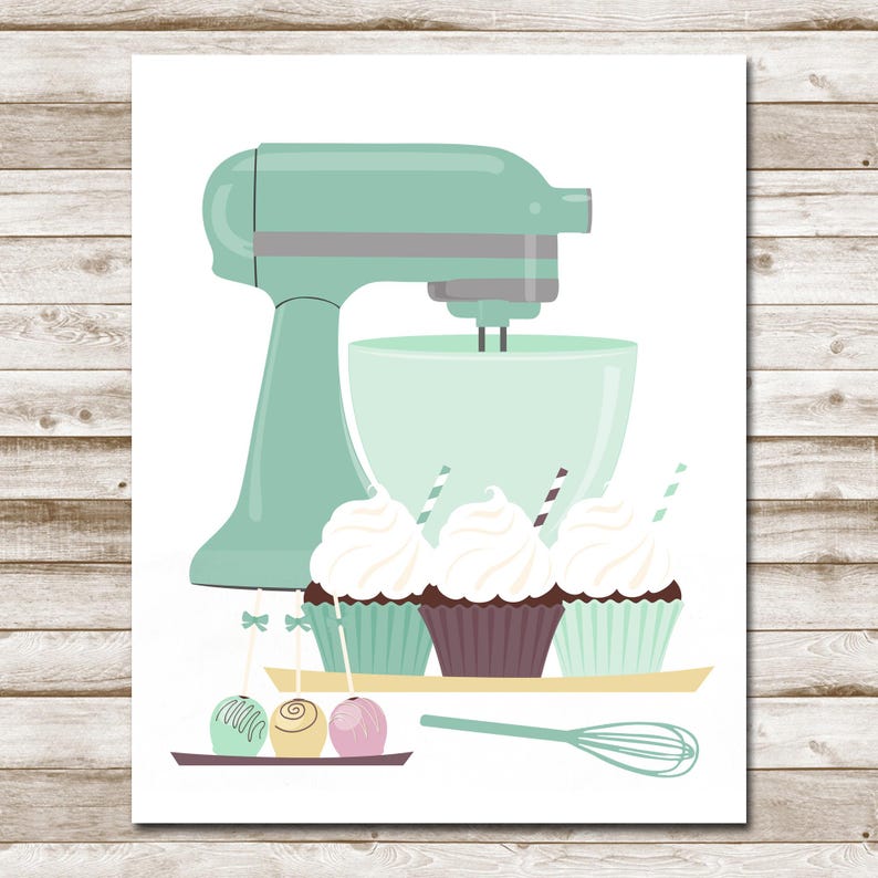 May include: A mint green stand mixer with a white bowl and a whisk attachment. Three cupcakes with white frosting and sprinkles are on a tray in front of the mixer. Three cake pops are on a tray below the cupcakes.