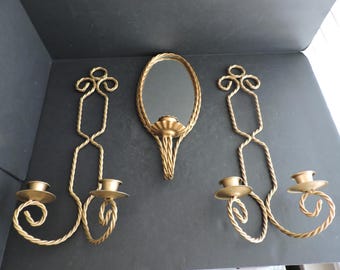 Könnte beinhalten: Set aus drei Vintage-Wandleuchtern aus goldfarbenem Metall und einem Spiegel. Die Wandleuchter haben ein gedrehtes Seildesign mit jeweils zwei Kerzenhaltern. Der Spiegel ist oval und hat einen passenden seilartigen Rahmen. Ein dekorativer Einrichtungsgegenstand.
