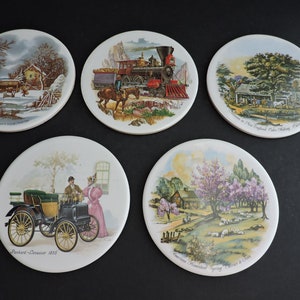 Puede incluir: Juego de cinco posavasos redondos de cerámica con escenas de paisajes vintage. Las imágenes incluyen una escena de invierno, un tren, una granja, un coche antiguo y una escena de primavera. Cada posavasos tiene una imagen diferente.