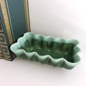 May include: A rectangular ceramic planter with a wavy, scalloped rim featuring a gradient glaze that transitions from a deep forest green at the base to a lighter, pale mint green along the top edges, showcasing a smooth, glossy finish throughout.