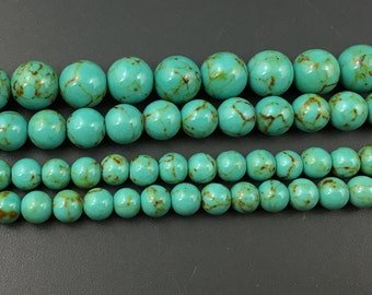 May include: A strand of turquoise blue beads with brown marbling. The beads are round and smooth, and they are arranged in a row.