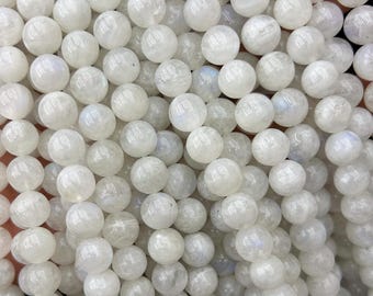May include: A strand of white moonstone beads. The beads are round and smooth, with a subtle iridescent sheen.