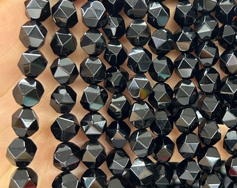 May include: A strand of black faceted gemstone beads. The beads are round and have a starburst pattern.