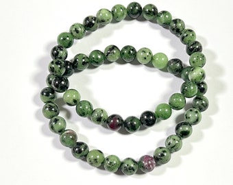 Può includere: Due braccialetti di pietre preziose verdi e nere con piccole perle rotonde.