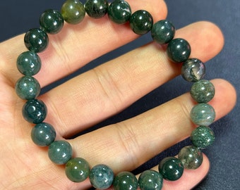 Può includere: Un braccialetto di perline di agata muschio verde con un motivo verde scuro e verde chiaro. Il braccialetto è fatto di perline rotonde ed è lungo circa 18 cm.