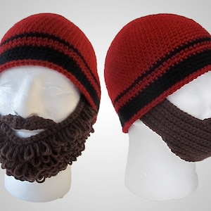May include: Two red knit hats with black stripes and brown knit beard attachments. The hats are worn on white mannequin heads.