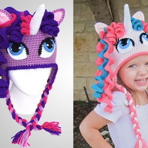 May include: Two crocheted unicorn hats, one purple and pink with a white horn, the other pink with a white horn and blue and pink mane. The pink hat is worn by a young girl.