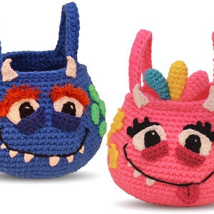 May include: Two crocheted monster-shaped baskets with handles. One is blue with green and orange details, the other is pink with yellow and blue details.
