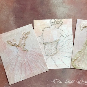May include: Four small paintings of ballerina dresses, each with a different design and color. The dresses are painted in a textured style, with a white background and a light pink, light gold, or white dress.