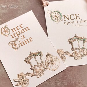 May include: Two pink cards with gold lettering and a green glitter design. The top card says "Once upon a time..." and the bottom card says "Once upon a time" with a gold carriage illustration.