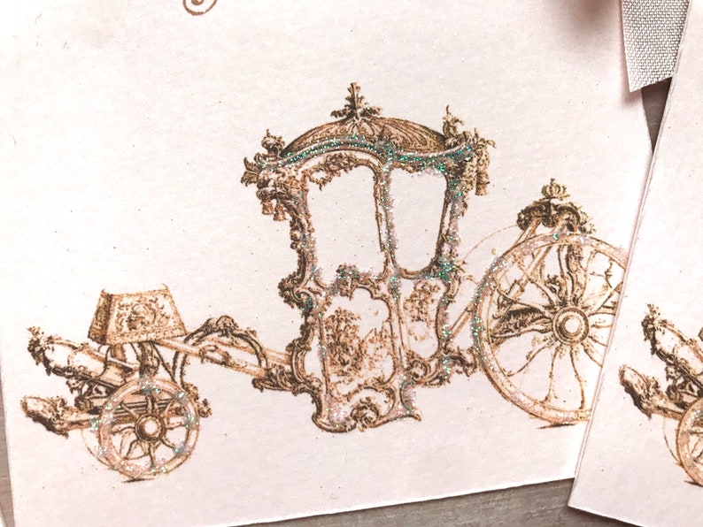 May include: A vintage illustration of a gold carriage with intricate details and a sparkling finish. The carriage has a large wheel and a smaller wheel on the back. The image is on a white background.