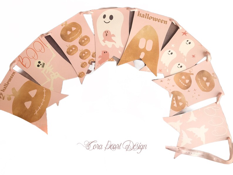 May include: A decorative bunting banner featuring a series of light pink pennants strung together with ribbon. The pennants display various Halloween-themed illustrations in gold and white, including pumpkins, ghosts, a skeleton, and the text BOO and halloween.