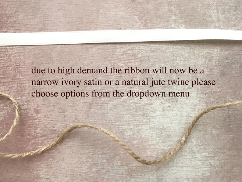 May include: A horizontal white satin ribbon and a length of natural jute twine. The text reads: due to high demand the ribbon will now be a narrow ivory satin or a natural jute twine please choose options from the dropdown menu.